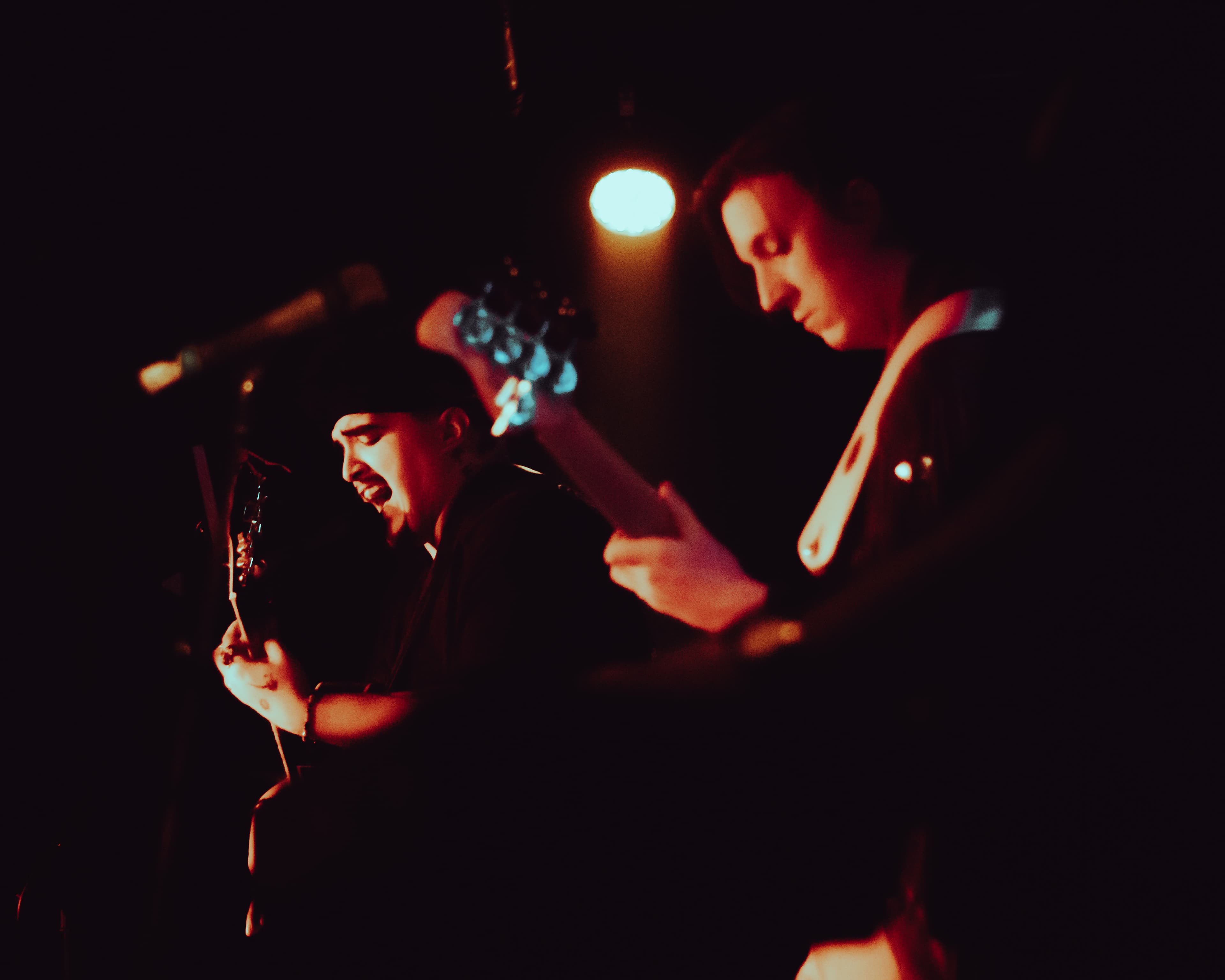 Band performing under red stage lights