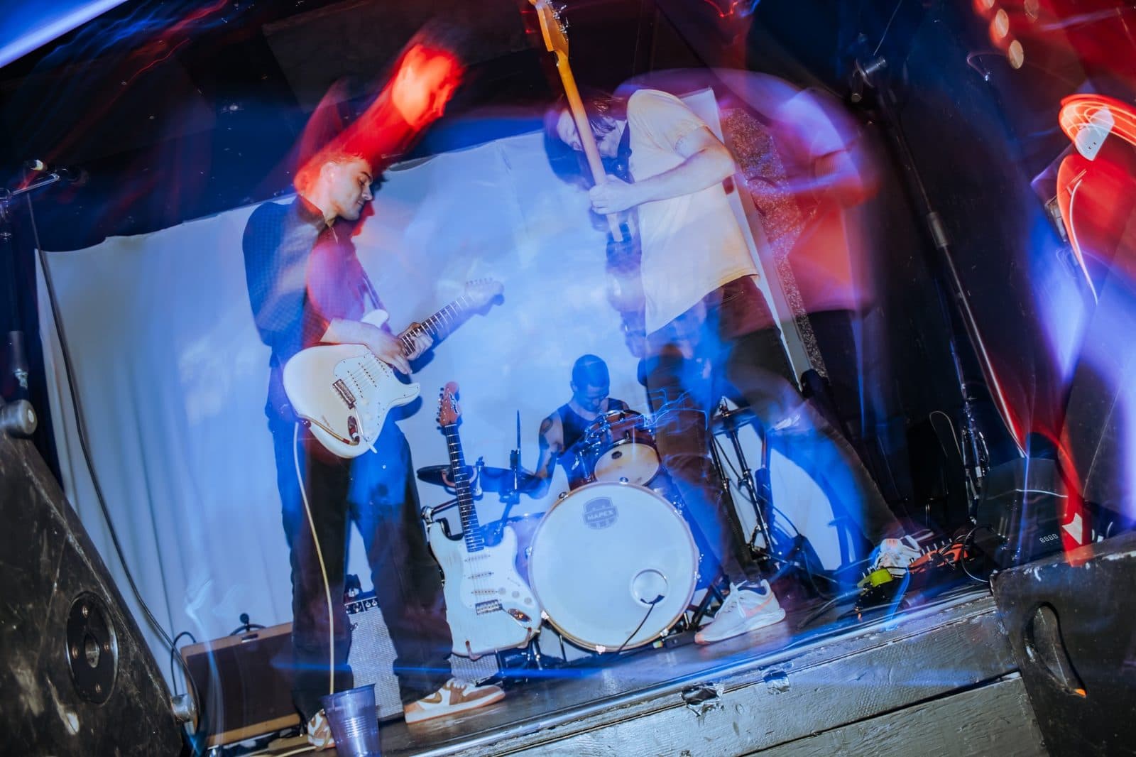 Caught Feelings performing on stage with colourful motion blur